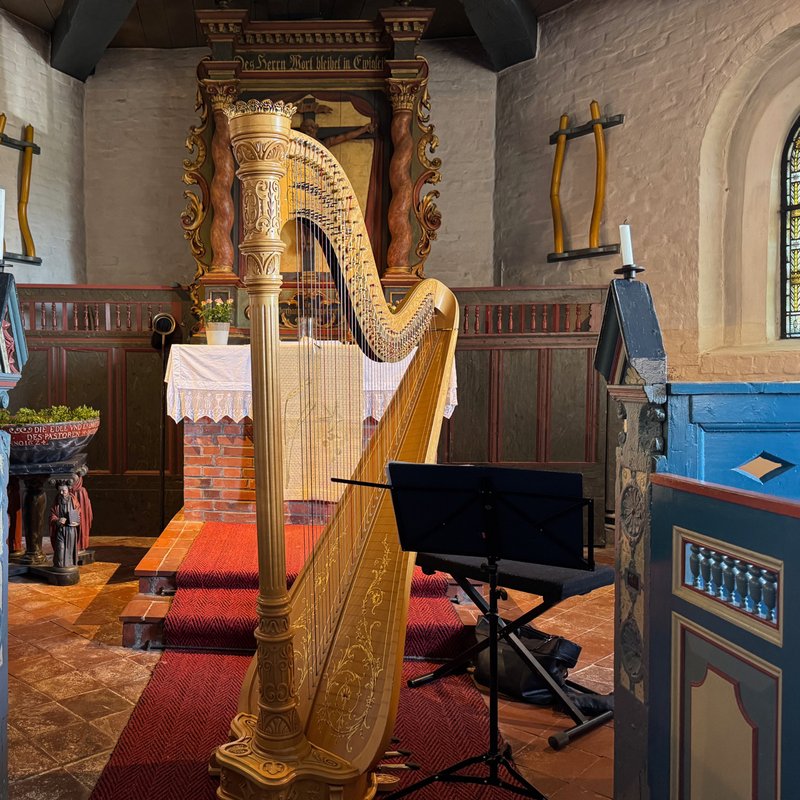 Innenraum der Halligkirche Hooge mit einer Harfe vor dem Altarraum