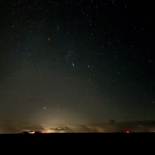 Sternenhimmel mit Lichtern am Horizont